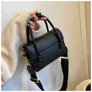 Vue détaillée du sac noir en cuir grainé avec finitions dorées et bandoulière large