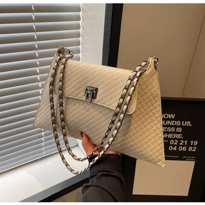 Detailansicht der beigen Stepptasche mit Metallverschluss und Leder-Kettenriemen