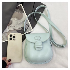 Detail of mint green crossbody bag with stripe embossing and adjustable shoulder strap