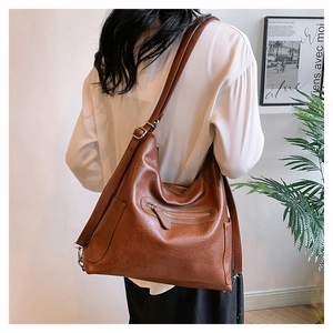 Dettaglio della borsa hobo grande marrone scuro con finitura in pelle sintetica martellata