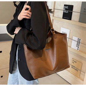Macro detail of brown pebble leather tote bag with elegant silver metallic hardware