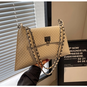 Detail der beigen gesteppten Ledertasche mit Metalldrehverschluss und Kettenriemen