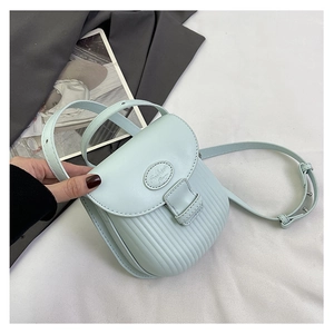 Detail of light blue textured small square bag with adjustable shoulder strap and logo