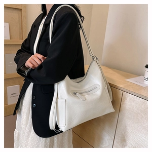 Dettaglio della grande borsa a tracolla bianca a pieghe con tasche laterali e frontali a zip