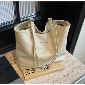 Close-up of litchi pattern leather tote bag with elegant silver metal bar detail