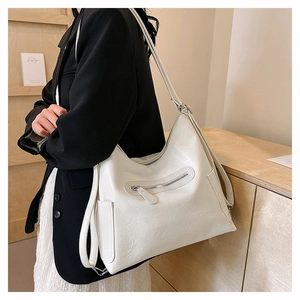Dettaglio della grande borsa tote bianca in pelle cerata con cerniera e tasche laterali