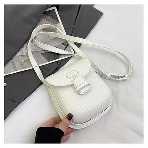 Detail view of white vertical embossed crossbody bag with faux leather and flap cover