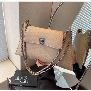 Detail der aprikosenfarbenen Web-Tasche mit Rautenmuster und grauem Metalldrehverschluss