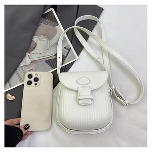 Detailed macro view of white PU leather crossbody bag featuring vertical pleated textures
