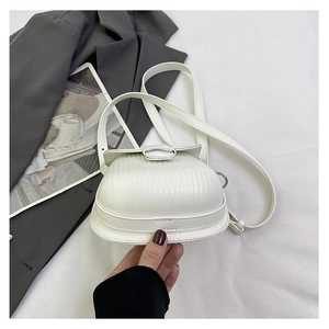 Detail view of the white ribbed texture and metallic ring buckle on the small shoulder bag
