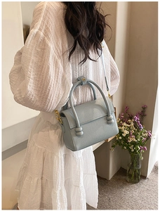 Détail du sac bandoulière bleu clair motif litchi avec poignée à détail noué
