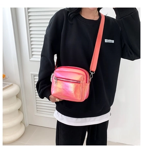 Detalle de bolso bandolera láser rosa holográfico con doble cremallera y correa de tejido