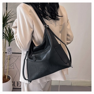 Dettaglio macro della trama in pelle martellata nera su una borsa hobo a spalla