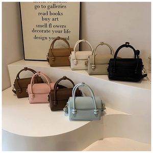 Sélection de huit sacs bandoulière en cuir grainé colorés sur un support minimaliste