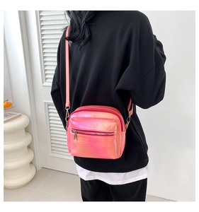 Vista posterior de una modelo con el bolso bandolera holográfico rosa con correa ajustable