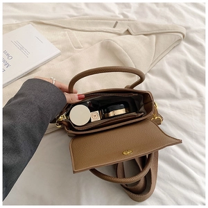 Vue intérieure du sac en cuir marron montrant le rangement pour rouge à lèvres et maquillage