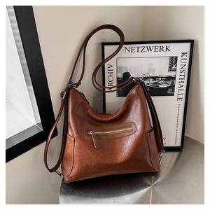 Dettaglio borsa a tracolla vintage marrone con tracolla larga e trama granata