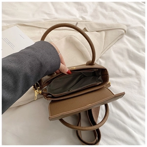 Détail intérieur du sac en cuir marron avec fermeture dorée et doublure en tissu