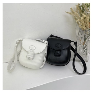 Detail view of mini pleated crossbody bags in black and white leather with metal clasps
