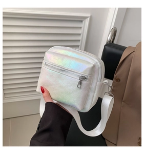 Detalle de bolso bandolera holográfico blanco con cremalleras plateadas y correa ancha
