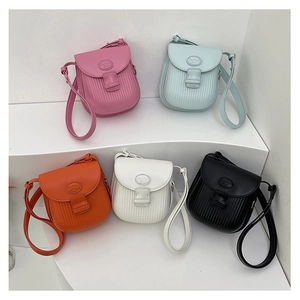 Detailed arrangement of five colorful textured crossbody mini bags on white geometric steps
