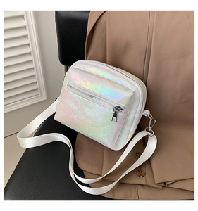 Bolso bandolera blanco iridiscente sobre chaqueta marrón con material de PU láser y cremallera