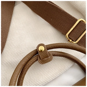Détails de la poignée en cuir et boucles dorées sur un sac à main marron chic