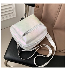 Detalle del bolso bandolera blanco iridiscente con cremallera plateada y correa ajustable