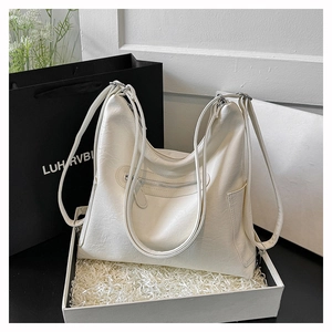 Dettaglio borsa tote in ecopelle crema con tasca zip in confezione regalo di lusso