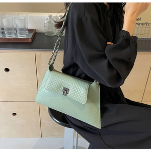 Detail einer mintgrünen Stepptasche mit silbernem Drehverschluss und Kettenriemen