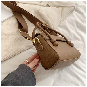 Gros plan d'un sac à main marron en cuir PU à motif litchi avec bandoulière large