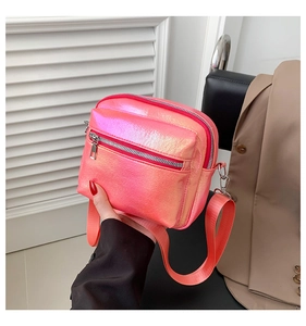 Detalle del bolso bandolera rosa láser metalizado con cremallera y correa de tela ancha