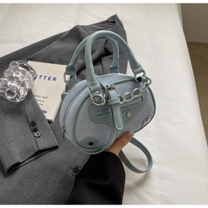 Light blue faux leather mini round bag featuring silver hardware studs and chain details