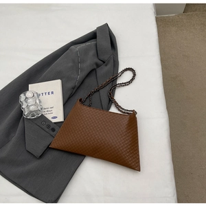 Nahaufnahme der braunen Stepp-Tasche mit Vintage-Metallkette in minimalistischem Stil