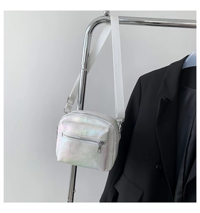 Detalle de bolso bandolera láser blanco con doble cremallera y correa ajustable
