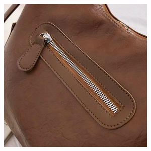 Dettaglio borsa in pelle marrone vintage con trama stropicciata naturale e zip argento