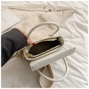 Détail du sac bandoulière blanc à motif litchi avec poche intérieure zippée et finitions dorées