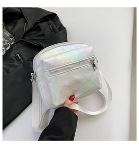 Detalle del bolso bandolera iridiscente con cremalleras plateadas y correa blanca