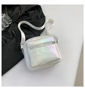 Detalle de bolso bandolera holográfico blanco con correa ancha y herrajes plateados