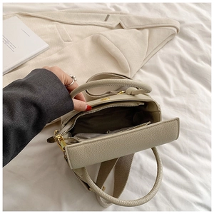 Vue détaillée du sac en cuir grainé beige montrant la doublure et la bandoulière