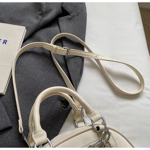 Detail of cream white mini crossbody bag with silver chain and adjustable strap