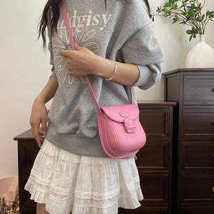 Pink faux leather crossbody bag with vertical textured patterns for spring and summer