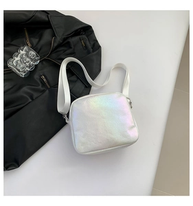 Vista detallada de un bolso bandolera holográfico blanco con acabado irisado y correa