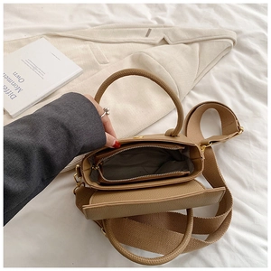 Vue intérieure du sac à main en cuir marron avec bandoulière large et dorures