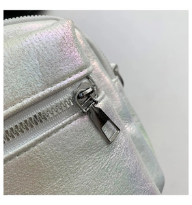 Detalle de cremallera plateada y cuero texturizado irisado en bolso bandolera