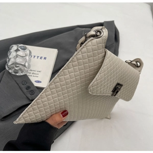 Nahaufnahme einer beigen gewebten Stepptasche mit Metallkette und Drehverschluss