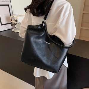 Minimalist black tote bag with lychee texture leather and silver hardware accents