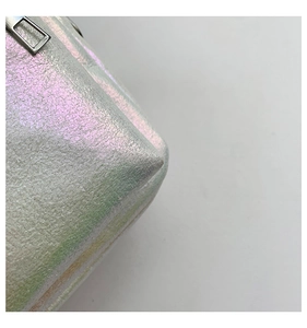 Detalle del bolso bandolera plateado holográfico con textura litchi y cremallera
