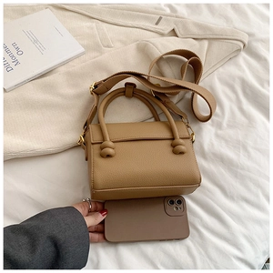 Détails du mini sac en cuir grainé marron avec poignées nouées et bandoulière large
