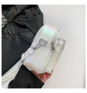 Detalle del bolso bandolera de PU blanco láser con acabado iridiscente y ganchos de plata